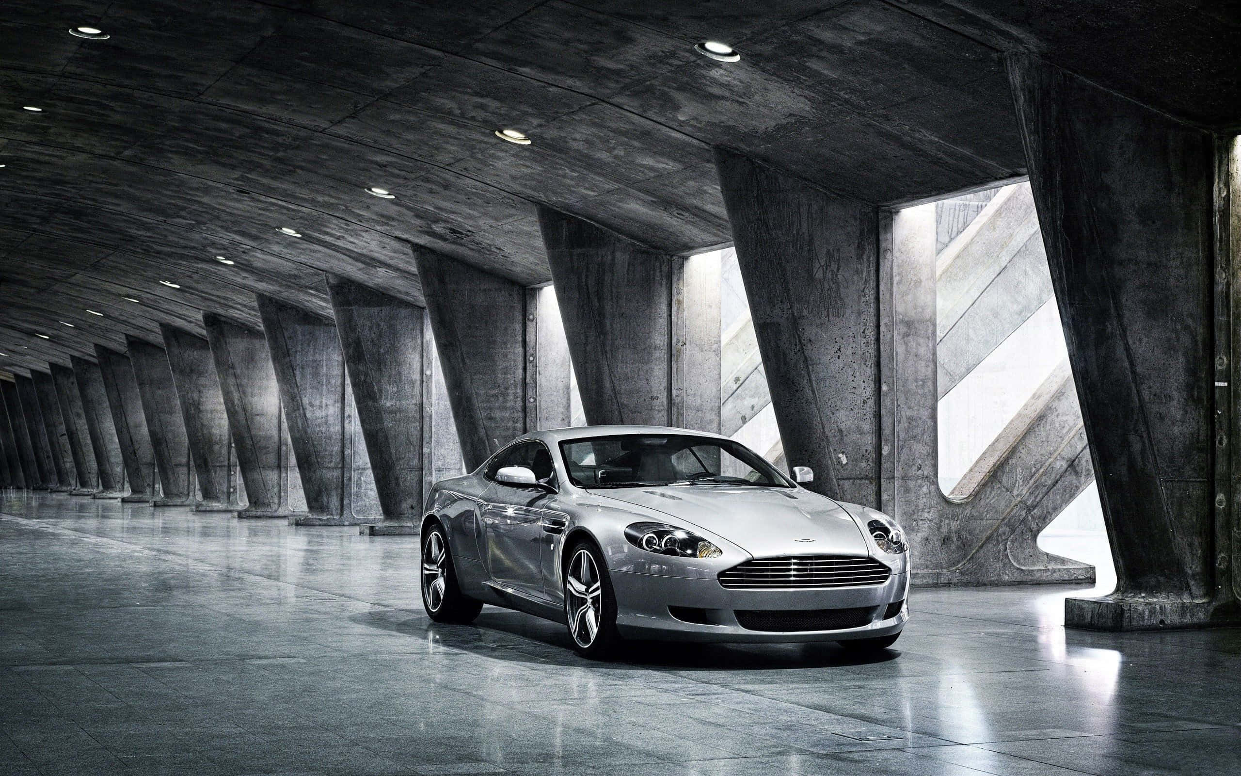 Aston Martin DB9, путешествующий по живописному городскому пейзажу Обои