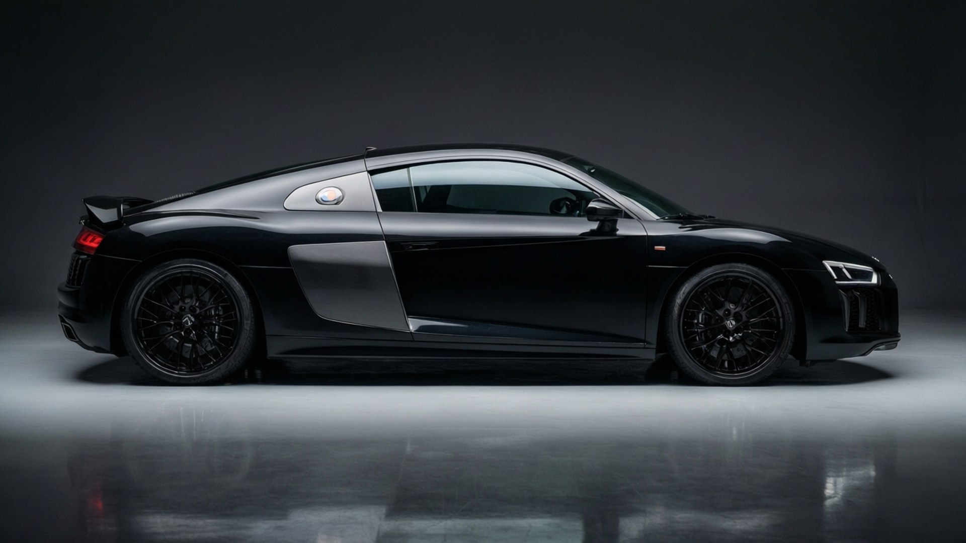 Черный Audi R8, снятый в чистой студийной обстановке, подчеркивающей его элегантный дизайн.