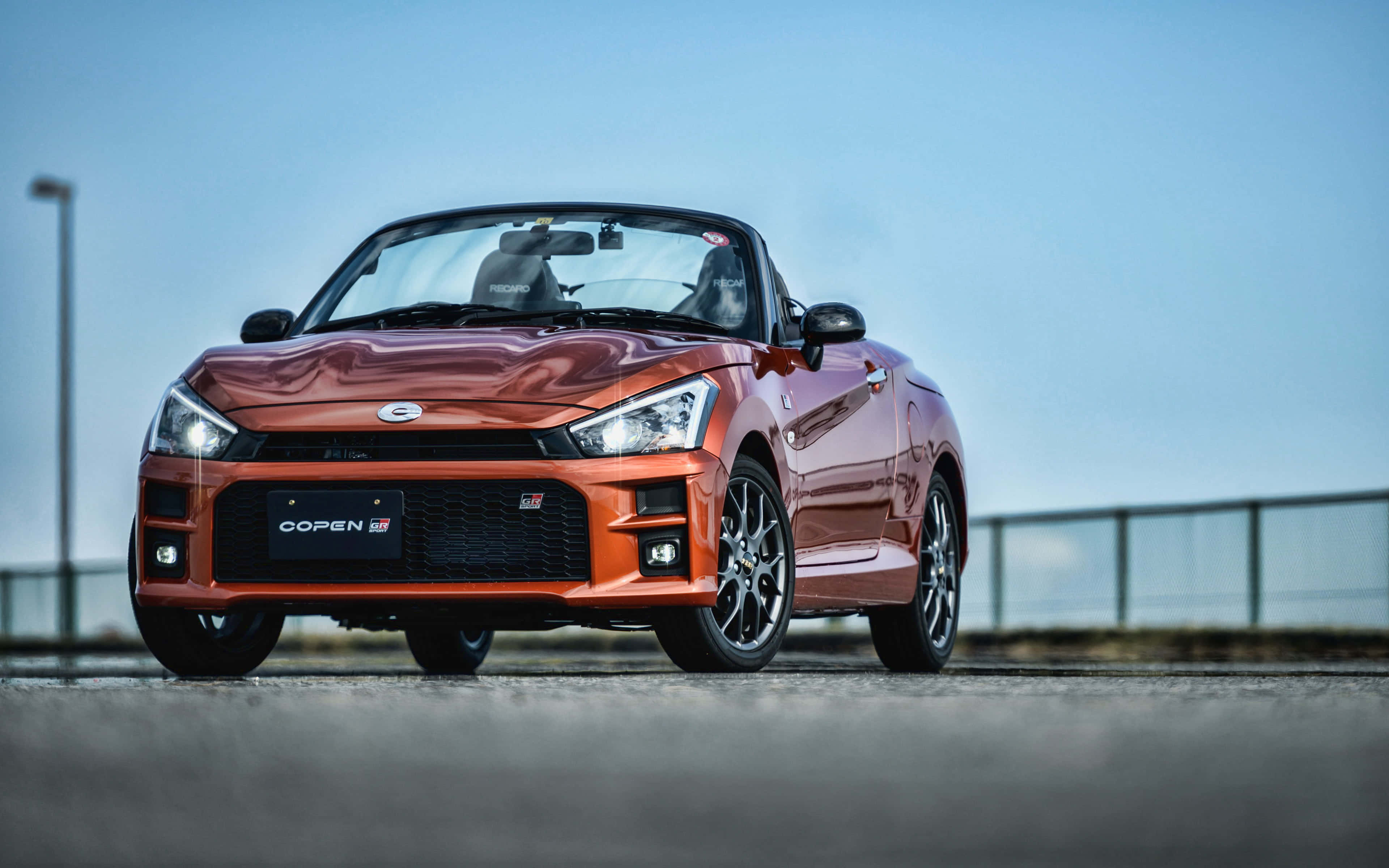 Стильный автомобиль Daihatsu едет по открытой дороге Обои