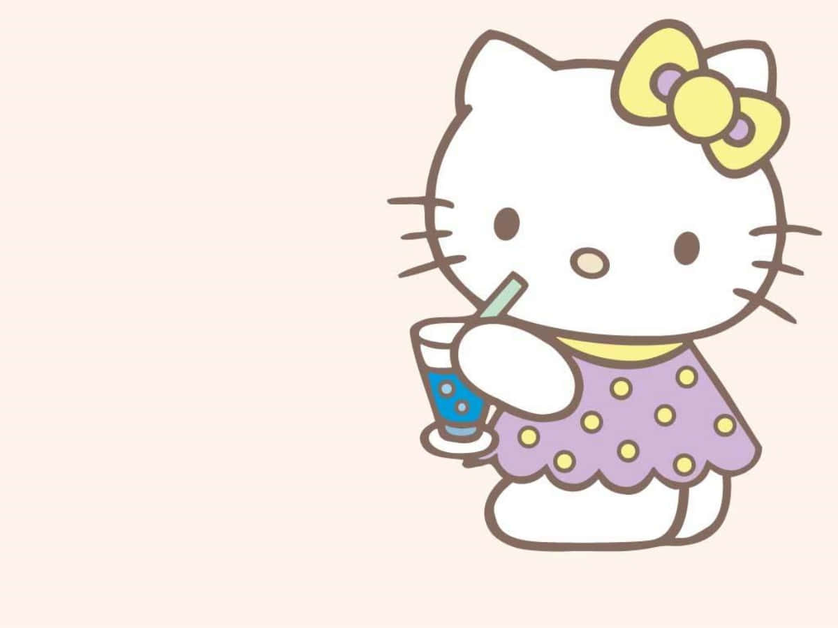 Hello Kitty пьет напиток за ноутбуком Обои
