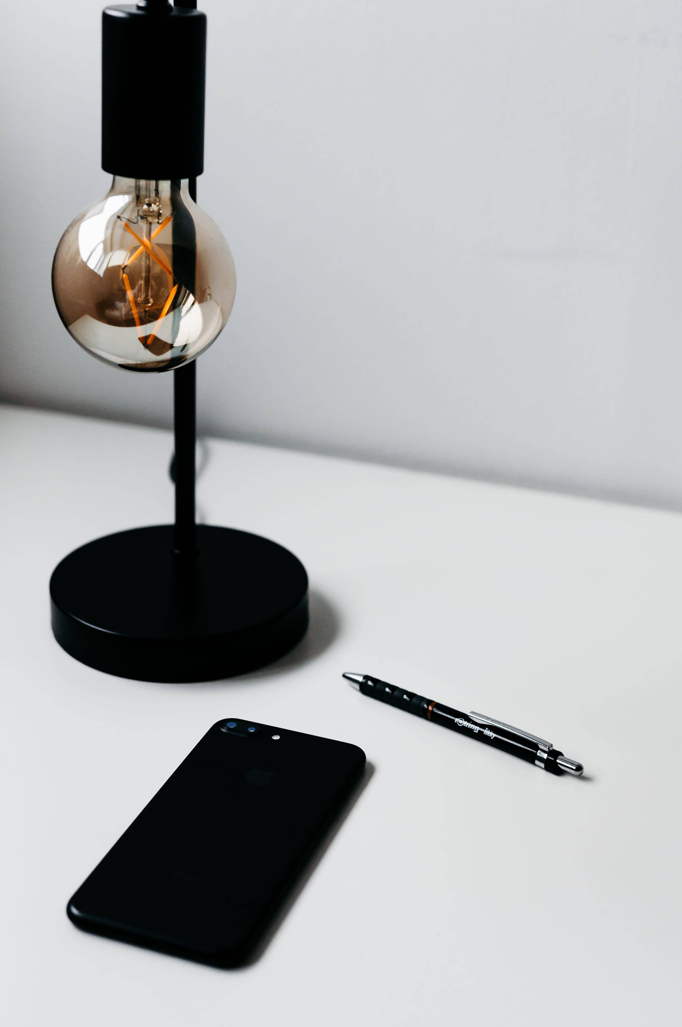 Подсвеченный iPhone на минималистичном столе Обои