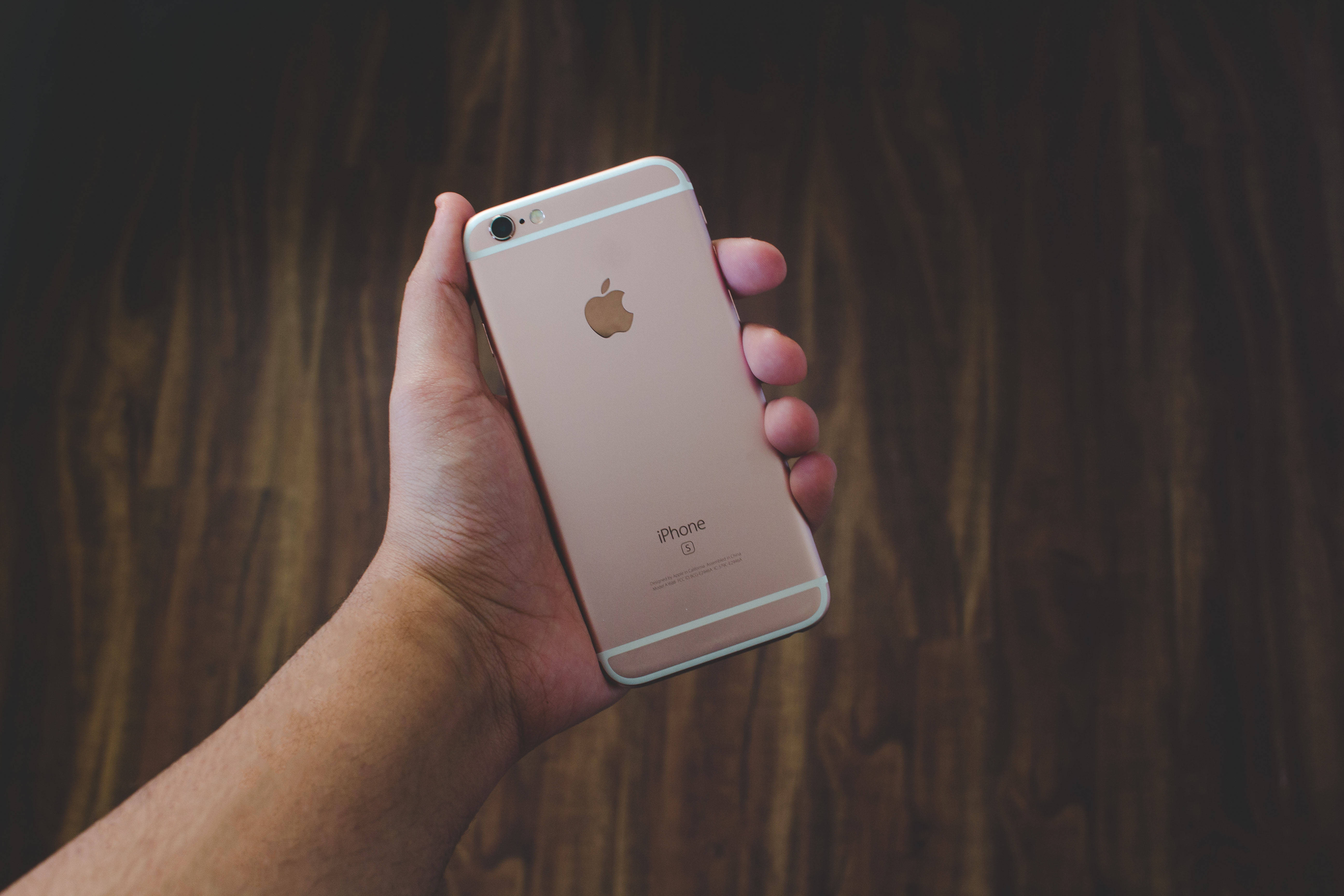 Рука, держащая розово-золотой iPhone 6 Обои
