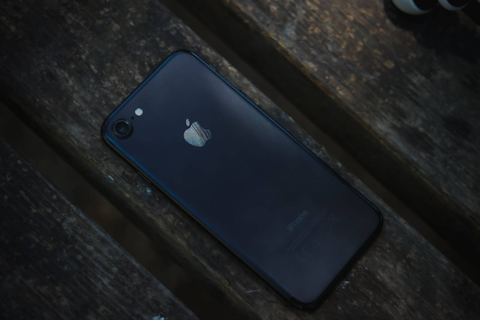 Темный iPhone 7 на дереве Обои
