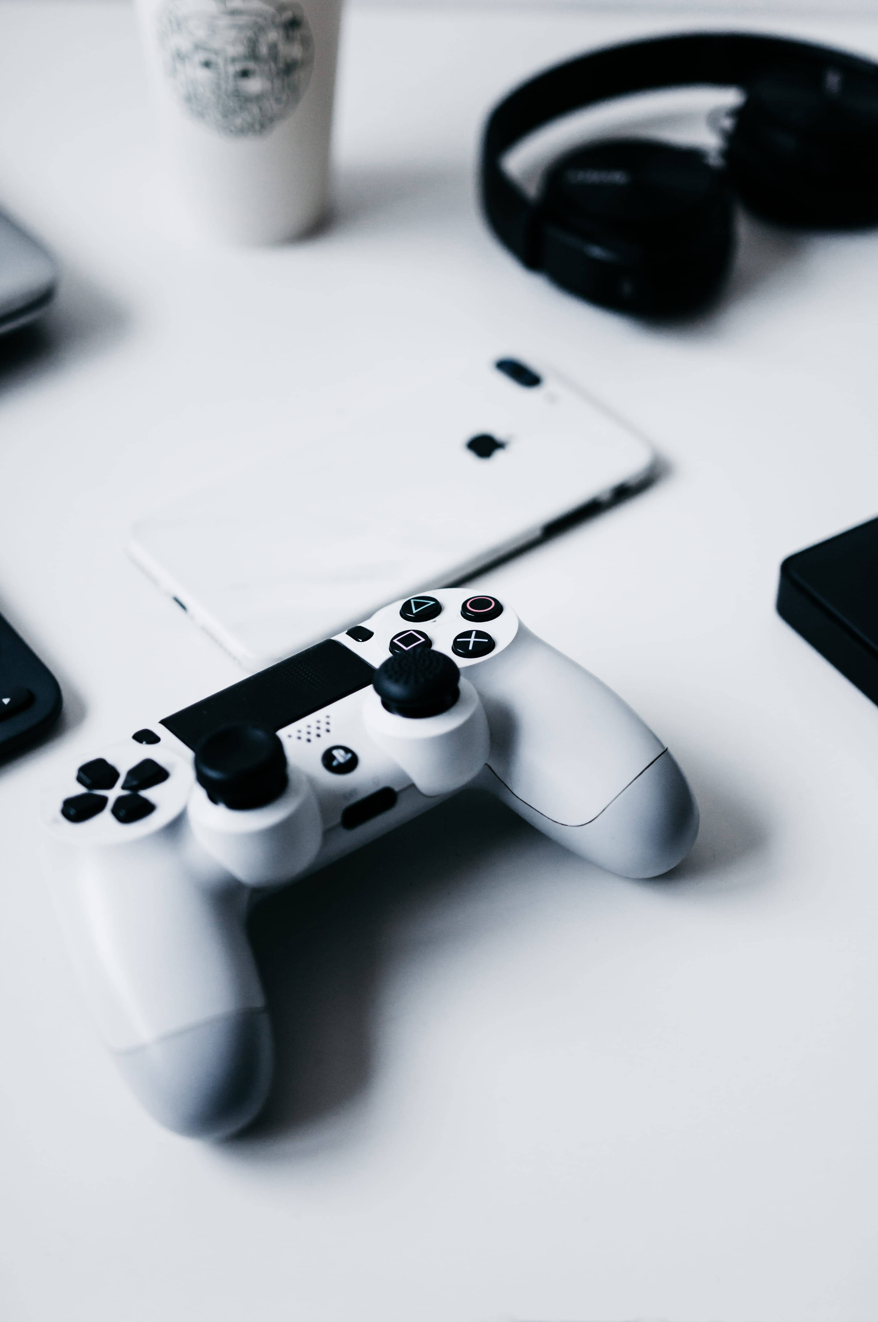 iPhone на столе с геймпадом PlayStation Обои