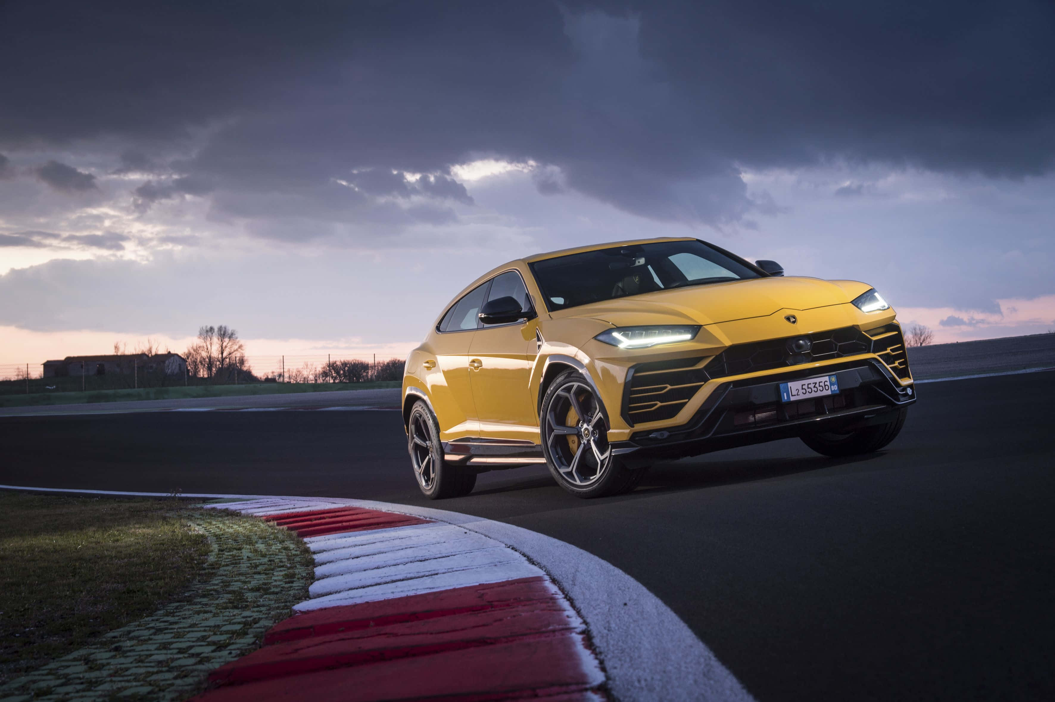 Lamborghini Urus — жёлтый внедорожник едет по треку Обои