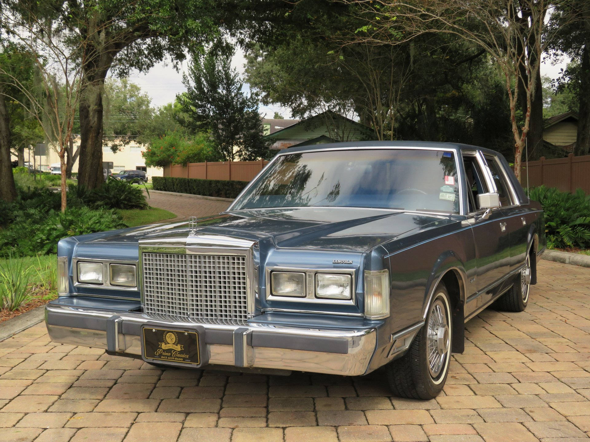Величественный Lincoln Town Car 1986 года на асфальтированной подъездной дорожке Обои