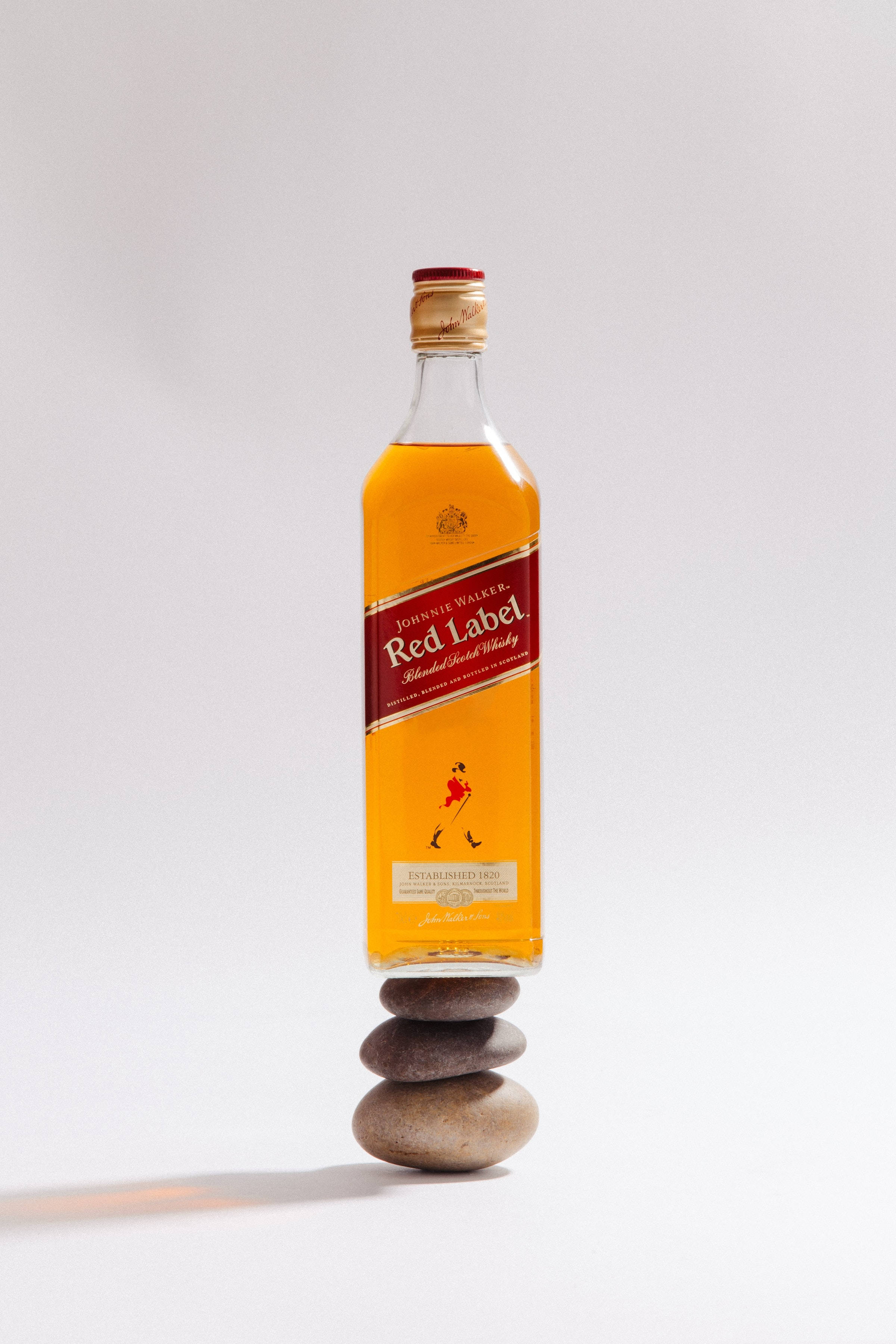 Бутылка виски Red Label на стопке камней Обои