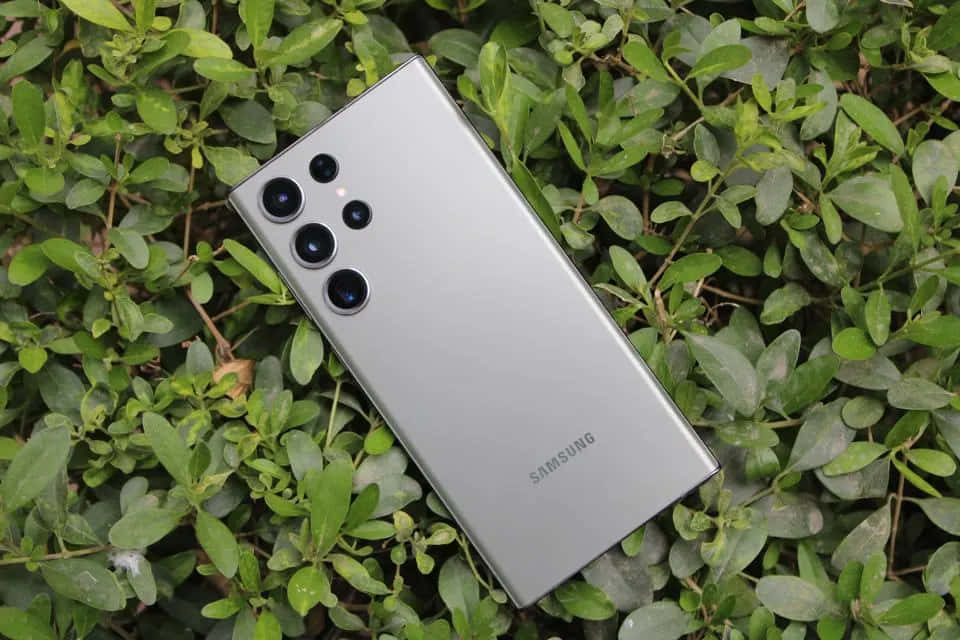 Samsung S23 Ultra на фоне зеленых листьев Обои