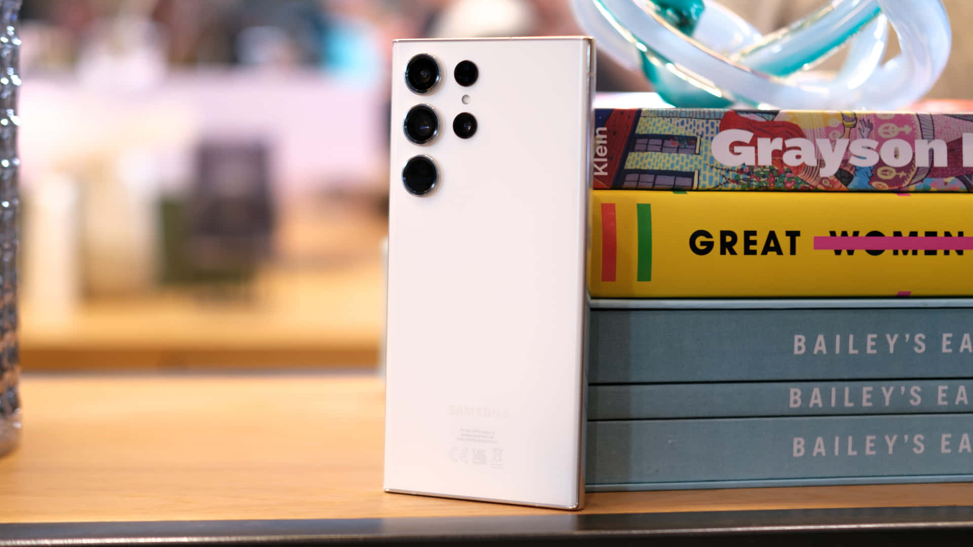 Samsung S23 Ultra кремового цвета на стопке книг Обои