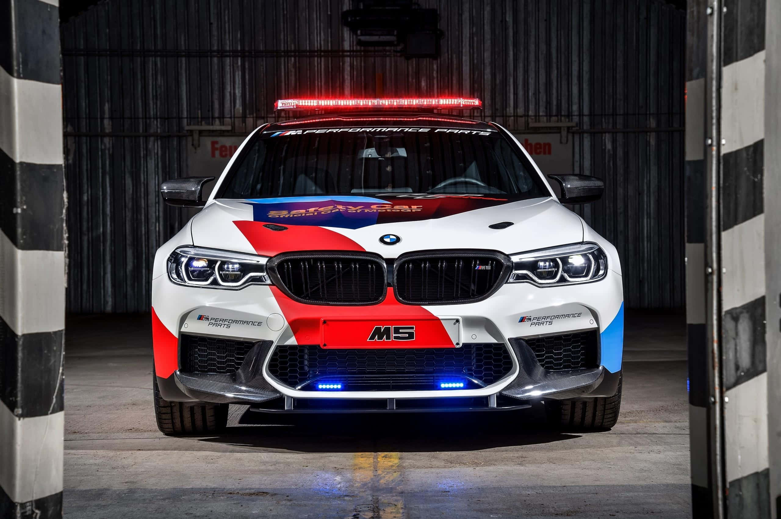 Высокопроизводительный автомобиль безопасности, мчащийся по гоночной трассе Обои