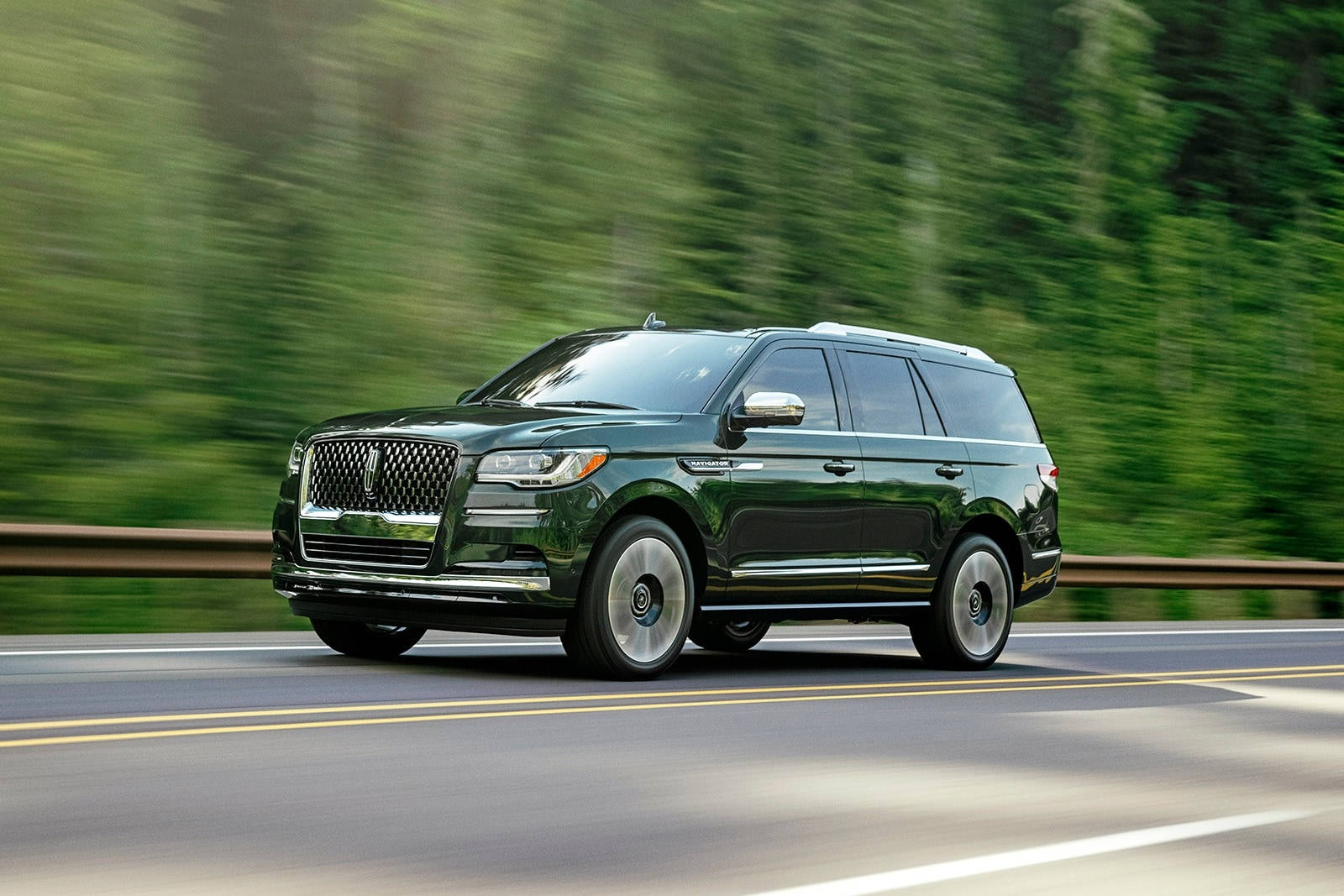 Черный Lincoln Navigator в движении у леса