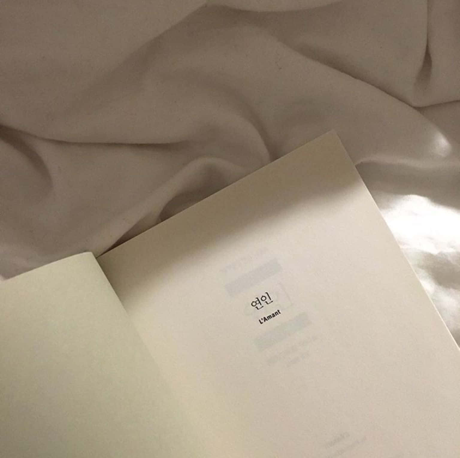 книга в белой обложке на кровати Обои