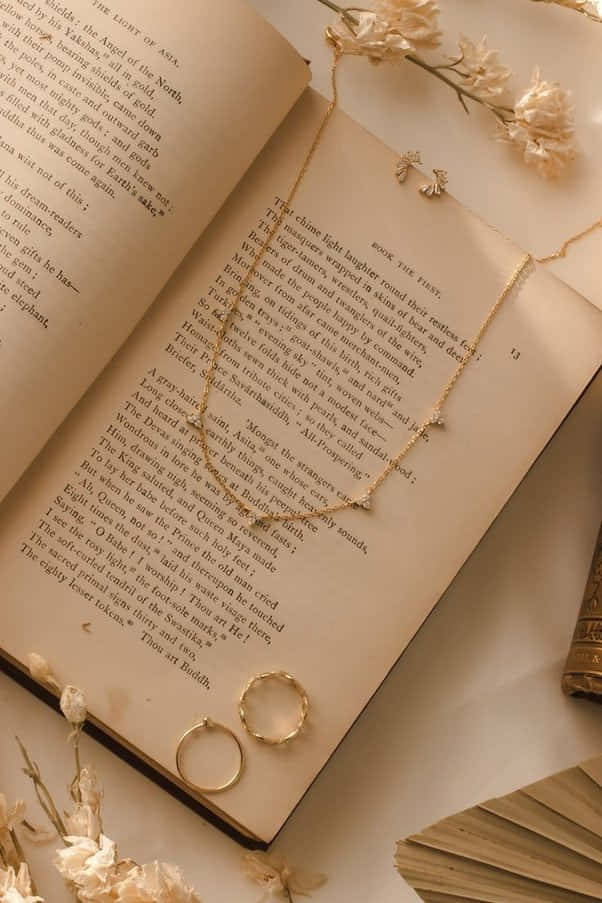 книга с ожерельем и кольцом на ней Обои