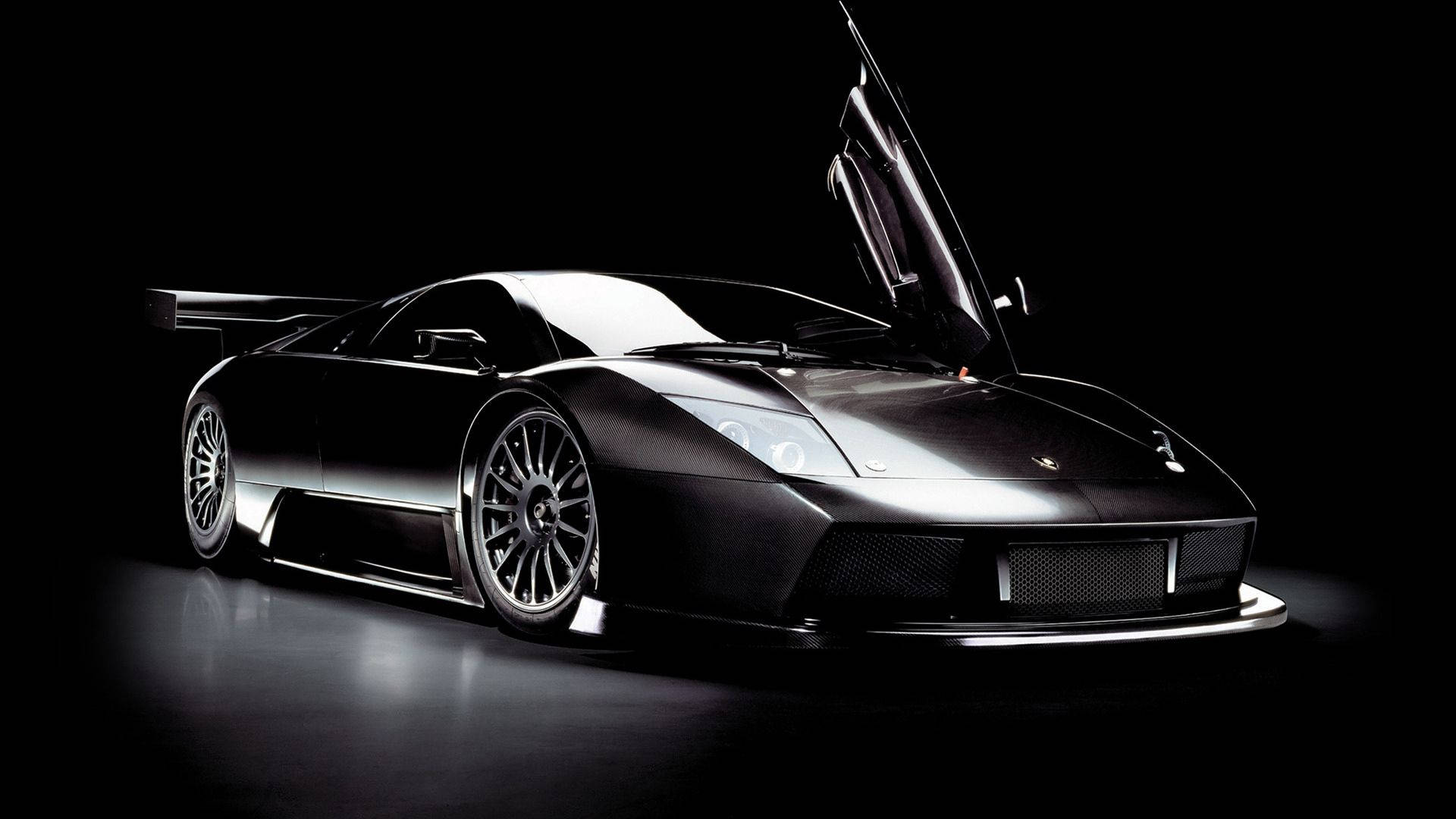 Потрясающие обои с черным Lamborghini с открытыми дверями.