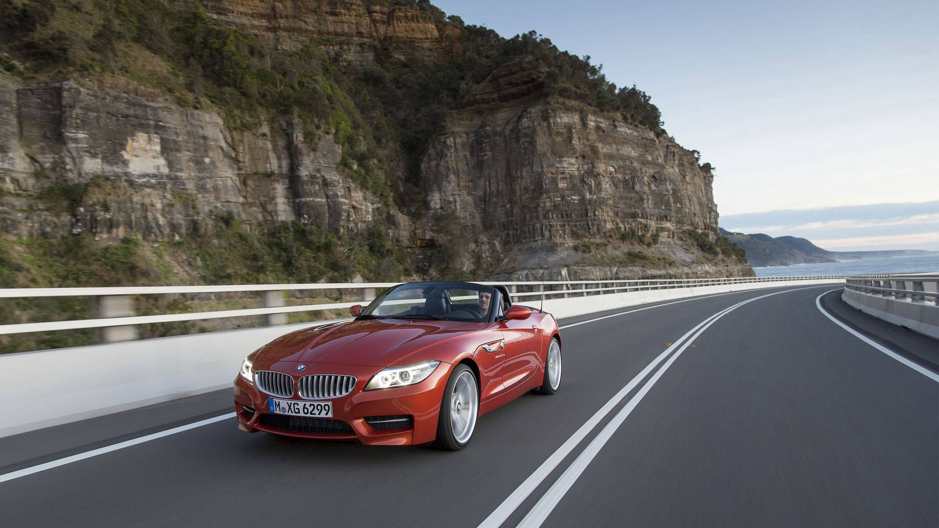 Оранжевый BMW Z4 на дороге у горы обои