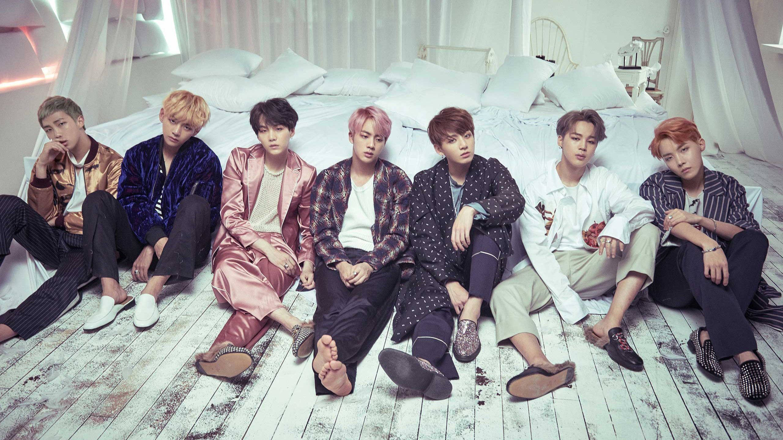 Участники BTS у кровати с ноутбуком Обои