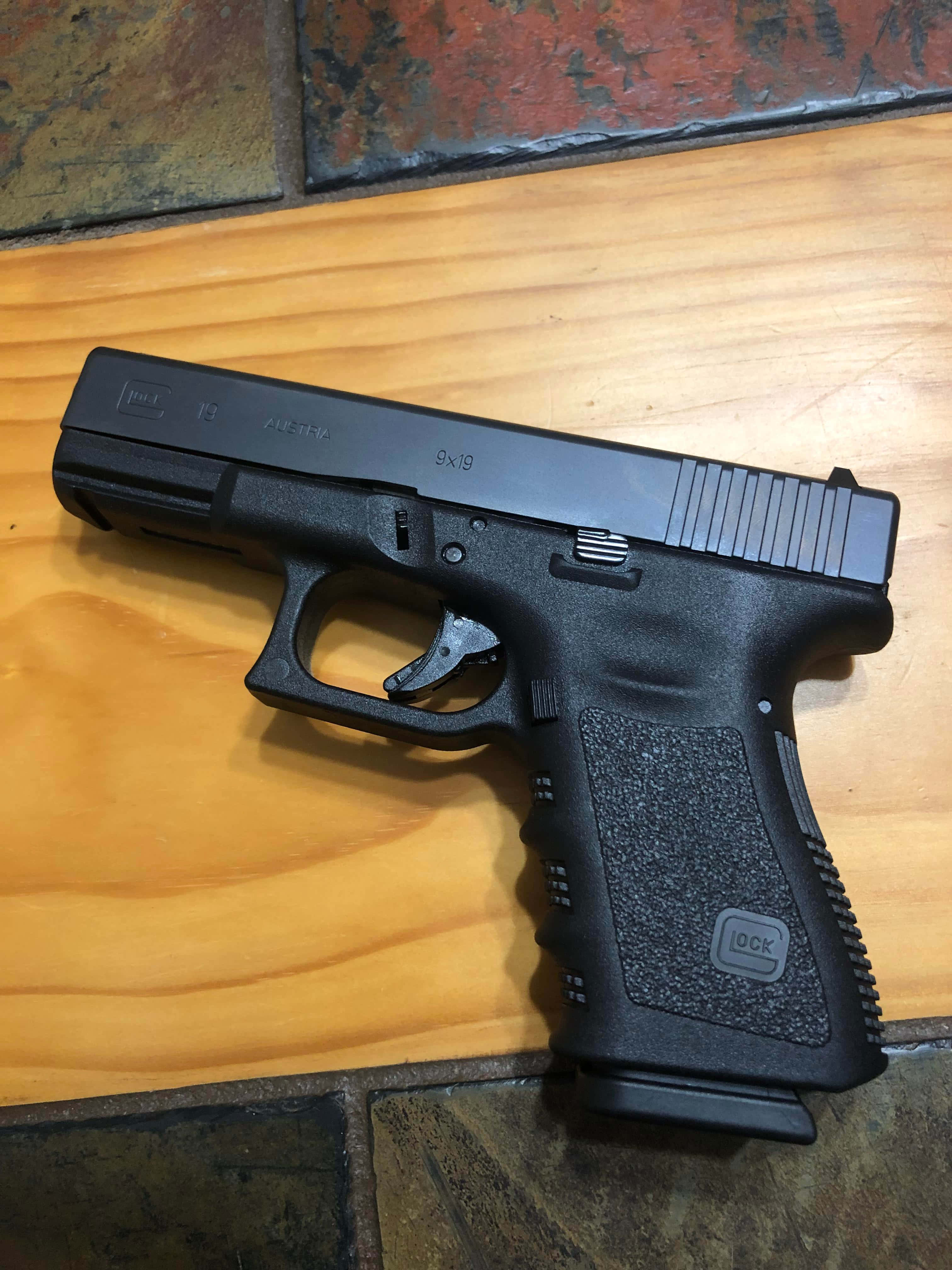 черный пистолет Glock на деревянном полу Обои