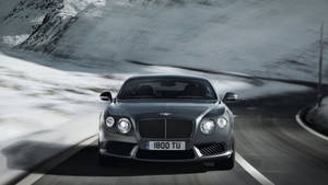 Обои Bentley, мчащегося по заснеженным горам — Зима Обои