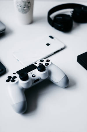 iPhone на столе с геймпадом PlayStation — Xiaomi Pad Обои
