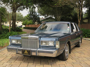Величественный Lincoln Town Car 1986 года на асфальтированной подъездной дорожке — Крутые машины гиф Обои