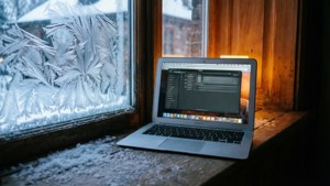MacBook Air на заснеженном подоконнике с уютным внутренним освещением. — MacBook Обои