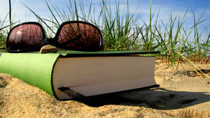 Летний отпуск с зеленой книгой и солнечными очками на песке. — Лето Обои