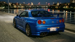 Синий Nissan GT-R на мосту ночью с отражениями города.