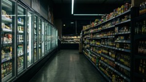 Мрачная ночная сцена с рядом продуктового магазина, освещённым только свечением холодильников.