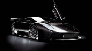 Потрясающие обои с черным Lamborghini с открытыми дверями.