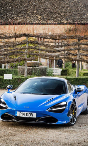Синий McLaren 720S в саду для телефона — Крутые машины гиф Обои